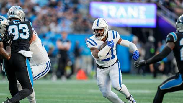 Nov 5, 2023; Charlotte, North Carolina, USA; Indianapolis Colts running back Zack Moss (21) runs through an opening defended by Carolina Panthers defensive tackle LaBryan Ray (93) during the first quarter at Bank of America Stadium. Mandatory Credit: Jim Dedmon-USA TODAY Sports